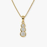 Round cut solitaire in three stone rub over setting